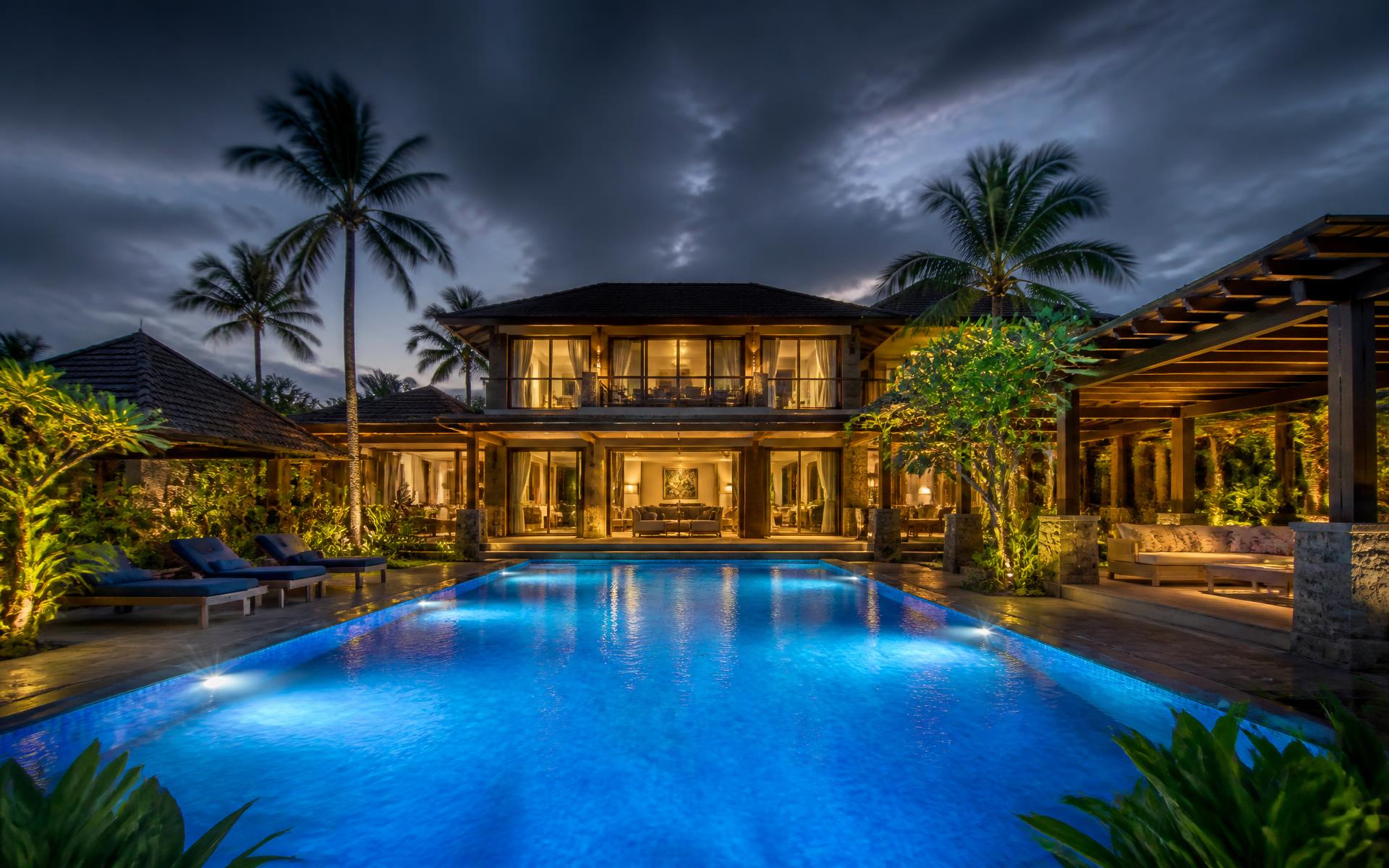 Luxury Indian villa swimming pool with brilliant blue water at dusk